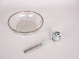 a glass bowl with a spoon next to it on a table