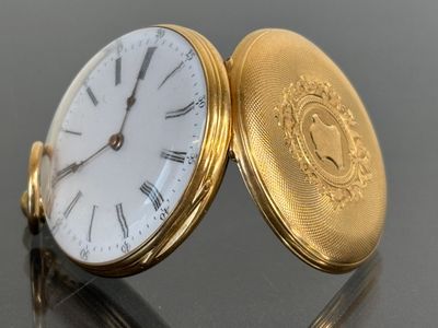 a close up of a gold pocket watch on a table