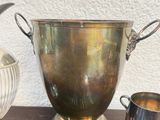 a silver vase and a silver spoon on a table