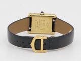 an image of a black and gold wrist watch with a gold buckle