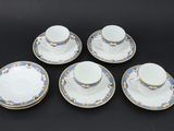 a set of four cups and saucers on a black background