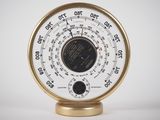 a white and gold clock on a gold stand
