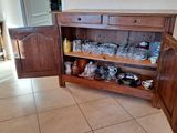 a wooden cabinet with a door open in a kitchen