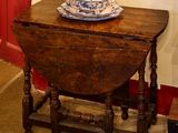 une petite table sur laquelle est posé un bol, devant un tableau