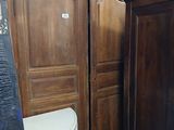 a wooden armoire next to a toilet in a room