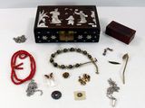 une boîte en bois sur laquelle sont disposés plusieurs bijoux