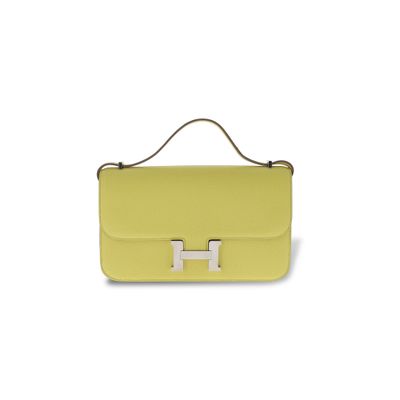 un sac à main jaune muni d'une poignée métallique sur fond blanc