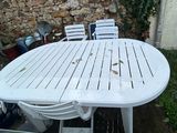 a white table and chairs outside in the yard