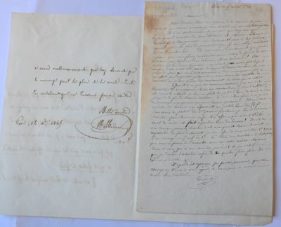two old papers with handwriting on them sitting on top of a table