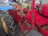 a red tractor that is parked in a garage