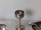 three silver spoons and a bowl on a glass table