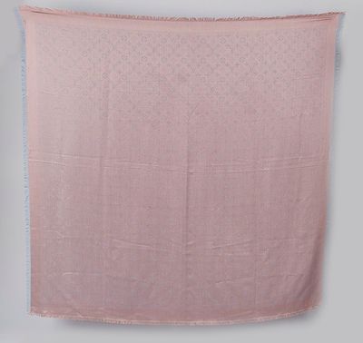 une couverture rose accrochée au mur à côté d'une chaise