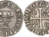 a silver coin with a cross on the front and a shield on the back