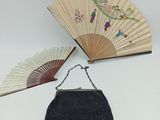 sac à main noir orné de perles, avec un éventail et une bandoulière à chaîne