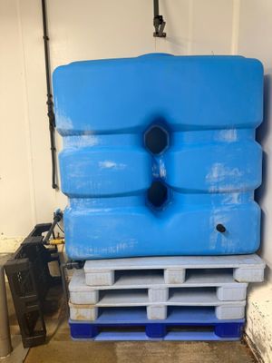un grand conteneur bleu posé sur une palette