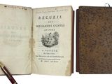 an old book with a pen sitting on top of it next to an open book