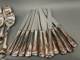 a lot of silverware on a table with a spoon and knife