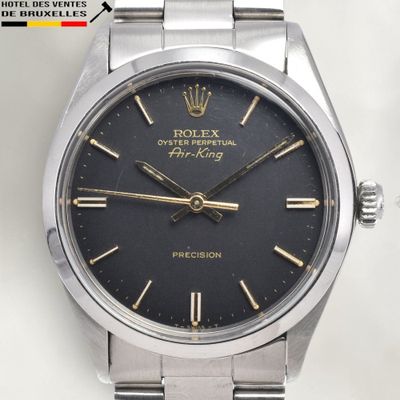 an image of a rolex watch with a black dial and gold hands