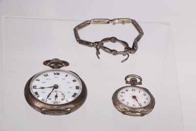 deux montres et un bracelet exposés dans une vitrine