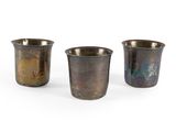 three small metal cups sitting next to each other on a white surface
