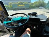 a man that is driving a truck with a steering wheel
