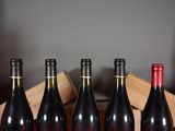 several bottles of wine are lined up in a wooden crate