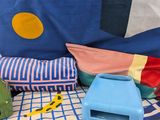 a bed with a blue and white blanket and a blue and yellow pillow and a blue and white pillow and a blue and white pillow and yellow pillow