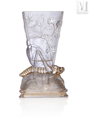 un vase en verre orné d'un insecte, posé sur un socle