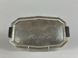 an antique silver plate with a black handle and a black band