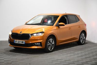a orange car is parked in a room with a checkered floor