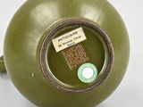 a green vase that has a tag on it