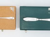 two different types of silverware on display in a box