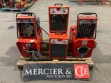 trois machines rouges posées sur une palette dans un entrepôt