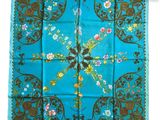 a close up of a blue and brown square scarf with flowers on it