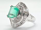 an emerald and diamond ring with baguets on a white background