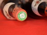 two bottles of wine sitting on a red cloth