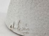 a close up of a white vase with writing on it