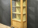 an old wooden display cabinet with glass doors in a room