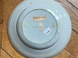 a plate with a sticker on it sitting on a wooden floor
