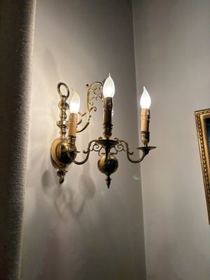 trois lampes accrochées au mur à côté d'un tableau