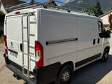 a white van parked in a lot with mountains in the background