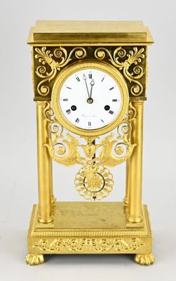 a gold clock that is sitting on a table