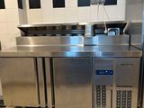 une grande cuisine en inox avec une crédence à carreaux