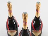 three bottles of champagne sitting on top of a white surface