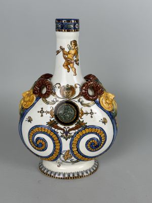 a white vase with a blue and gold decoration on it