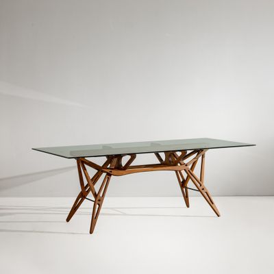 une table en verre avec des pieds en bois et un plateau en verre