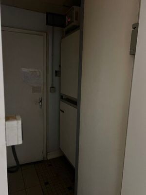 un réfrigérateur blanc dans un coin d'une petite pièce