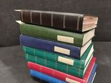 several books stacked on top of each other on a black surface