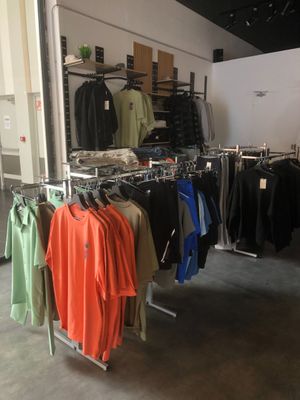 beaucoup de vêtements suspendus à une étagère dans une pièce