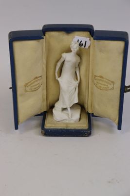 une figurine représentant une femme debout, exposée dans une vitrine